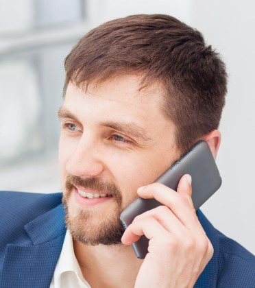 Portrait of businessman talking on mobile phone in office
